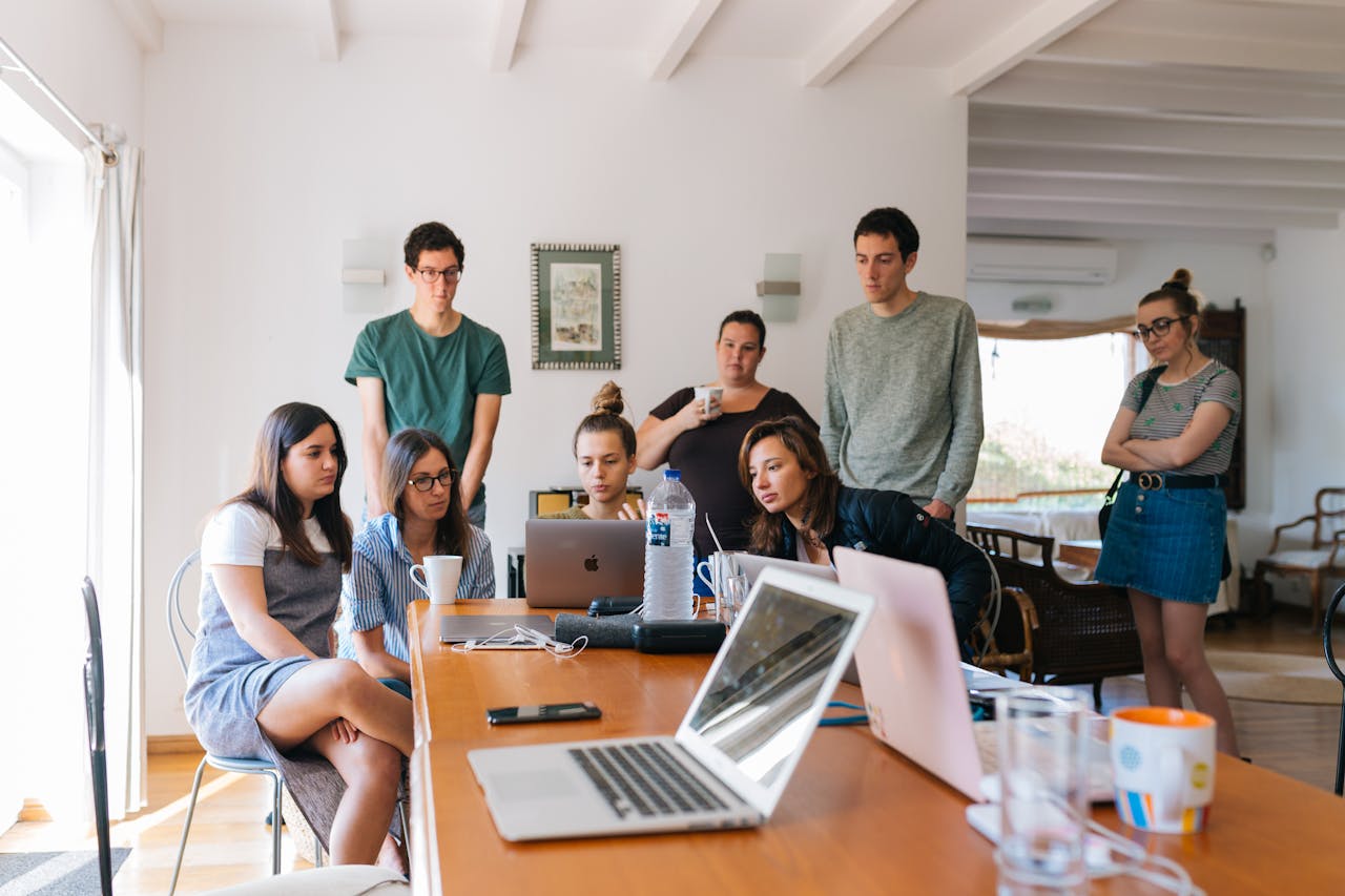 hero-img-01 Group of young professionals engaged in a collaborative meeting in a modern office setting.